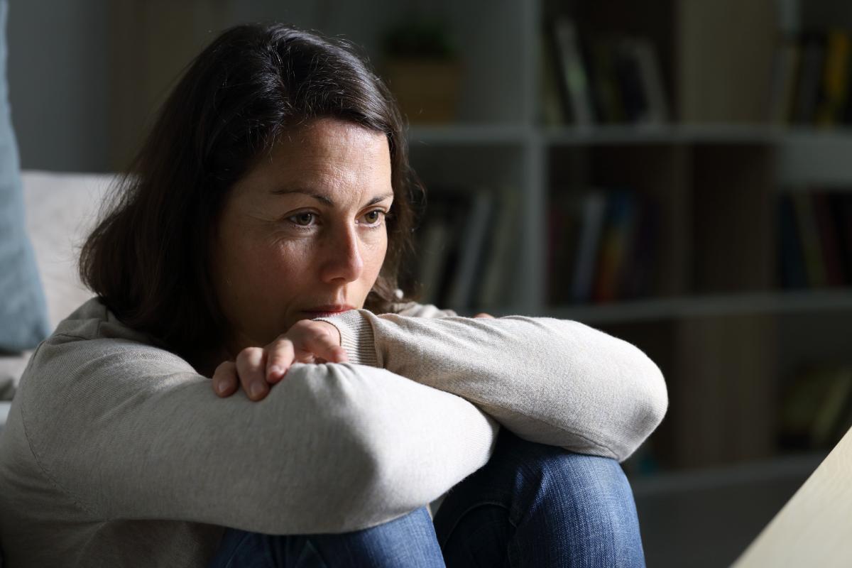 3 Signs of Meth Use in Adults A woman sits on the ground as she considers the physical signs of meth use in adults and the symptoms of meth addiction