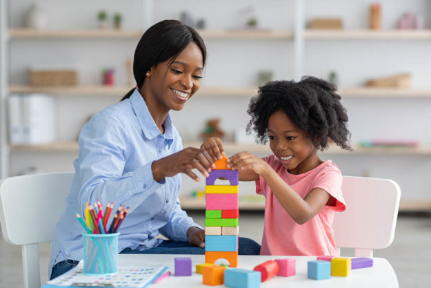 What is Play Therapy And How Does it Work A child building blocks and building confidence during play therapy