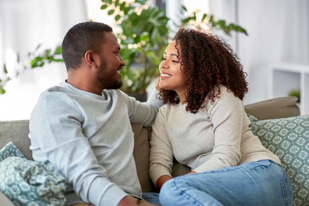 How to Maintain Your Relationship After Couples Therapy Couple sits on couch as they try to maintain their relationship after marriage counseling