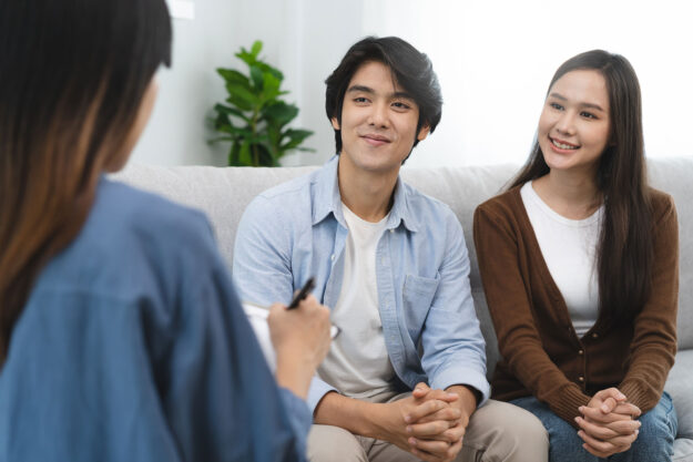 Couples Therapy Techniques to Help Your Relationship Couple sit on couch as they learn couples therapy techniques to save their relationship from therapist