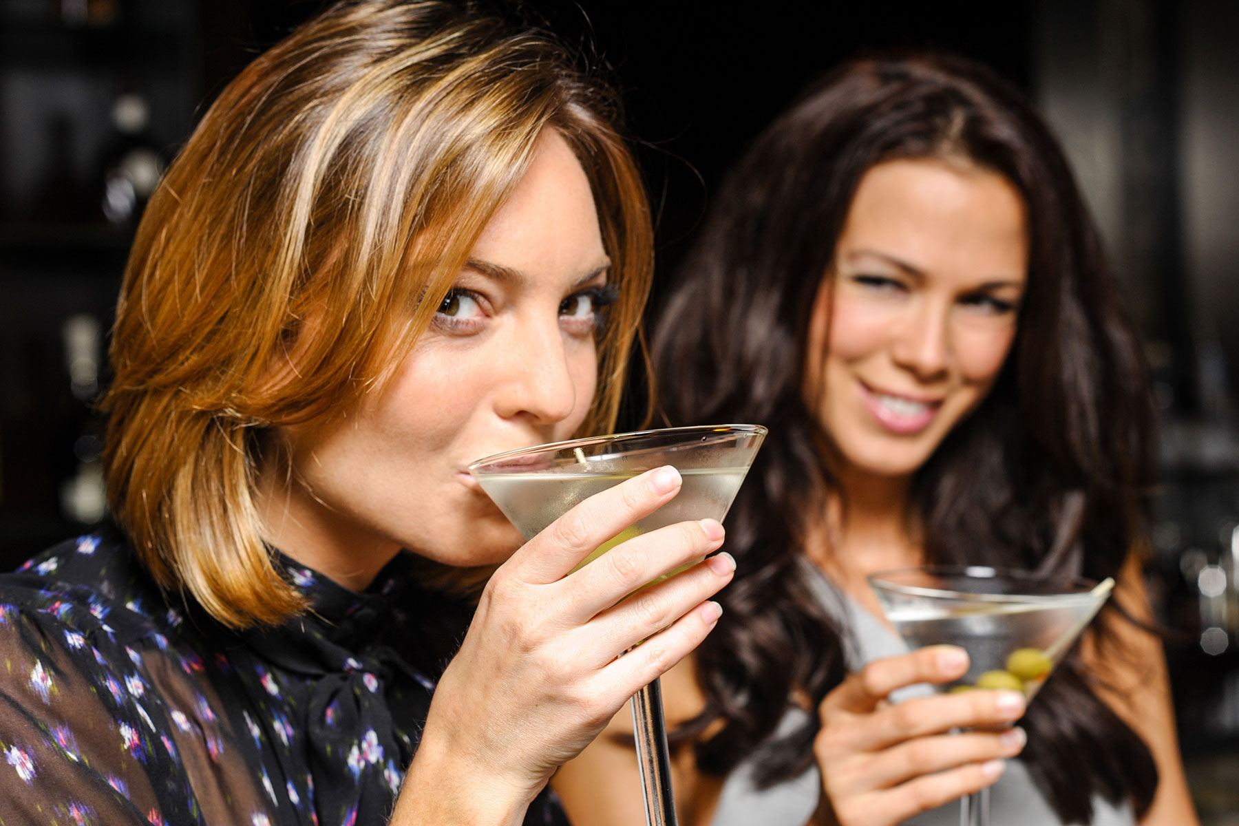 How Alcohol Consumption Could Disrupt Your Monthly Cycle Women sip martinis as they talk about how alcohol can disrupt monthly cycles
