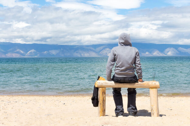 How To Overcome Your Meth Addiction and Reclaim Your Life Man sits on beach, thinking about how to overcome his meth addiction