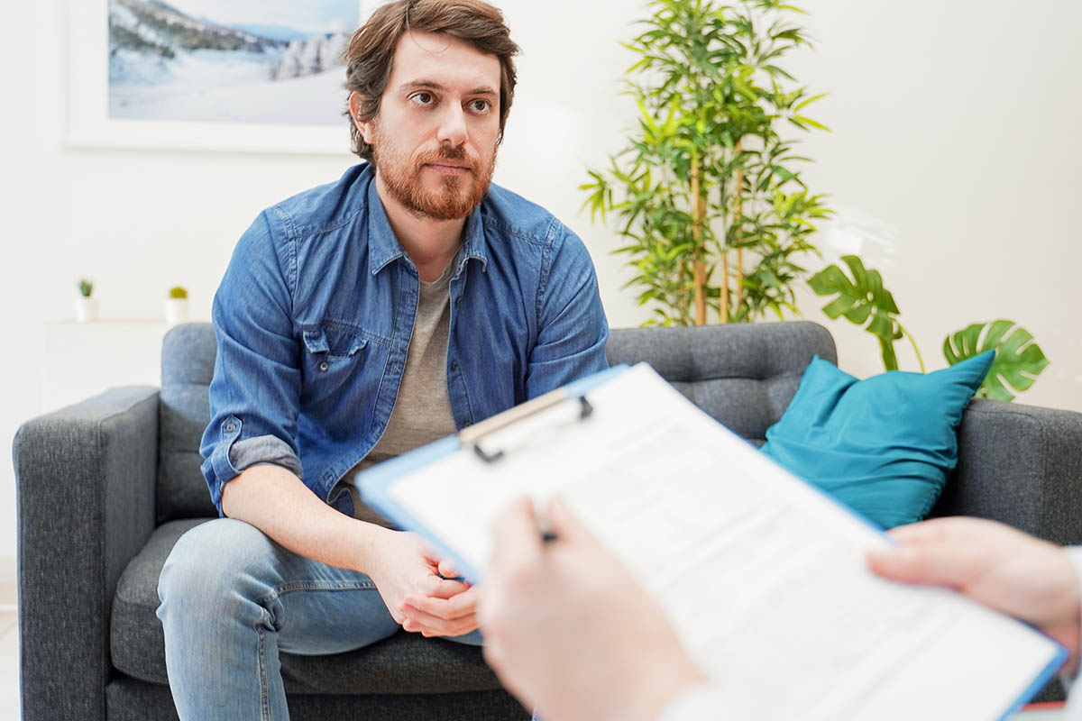 Man sits on couch and listens to the common signs of cocaine use