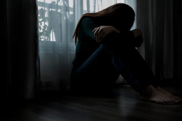 Meth Addiction- Treatment and Signs of Use Woman sits on the floor and struggles with the signs of meth use
