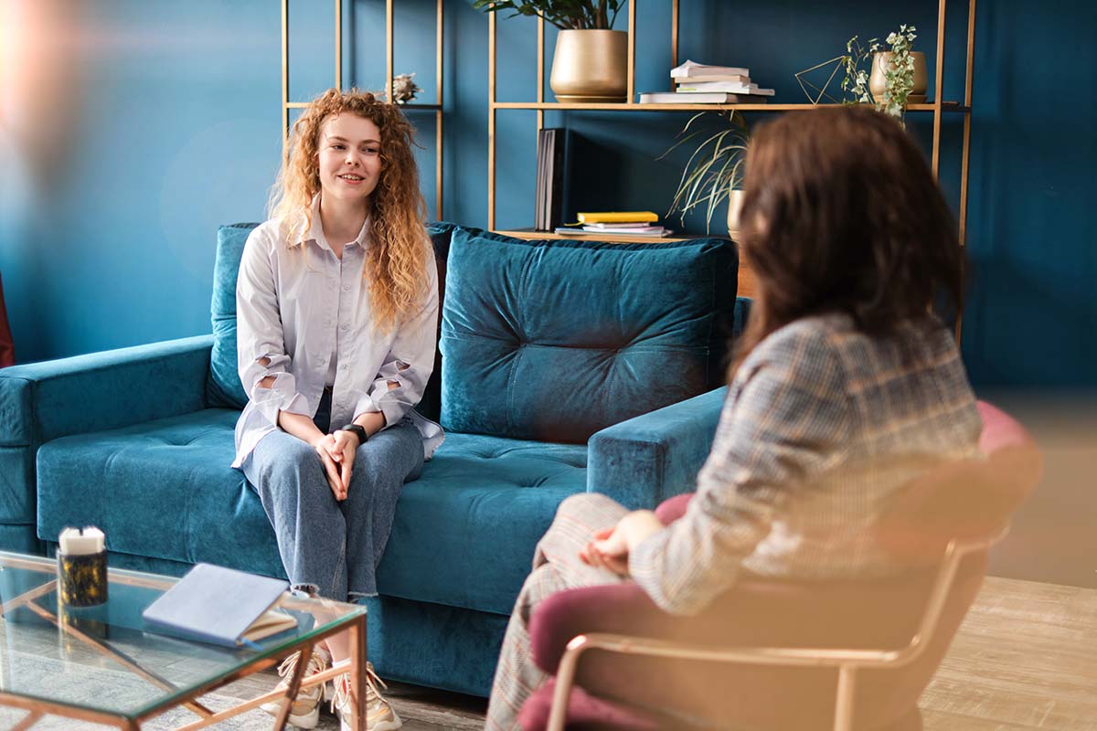 What Does IOP Mean – Intensive Outpatient Program FAQs Woman sits on couch and asks therapist, "what does IOP mean?"
