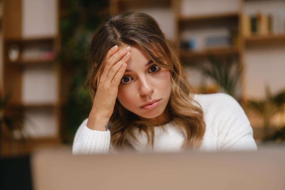 ADHD in Women Checklist- Do I Have ADHD Woman sits at computer in agony as she looks up an adhd in women checklist