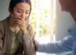 Woman begins to cry as father comforts her while they discuss acoa personality types
